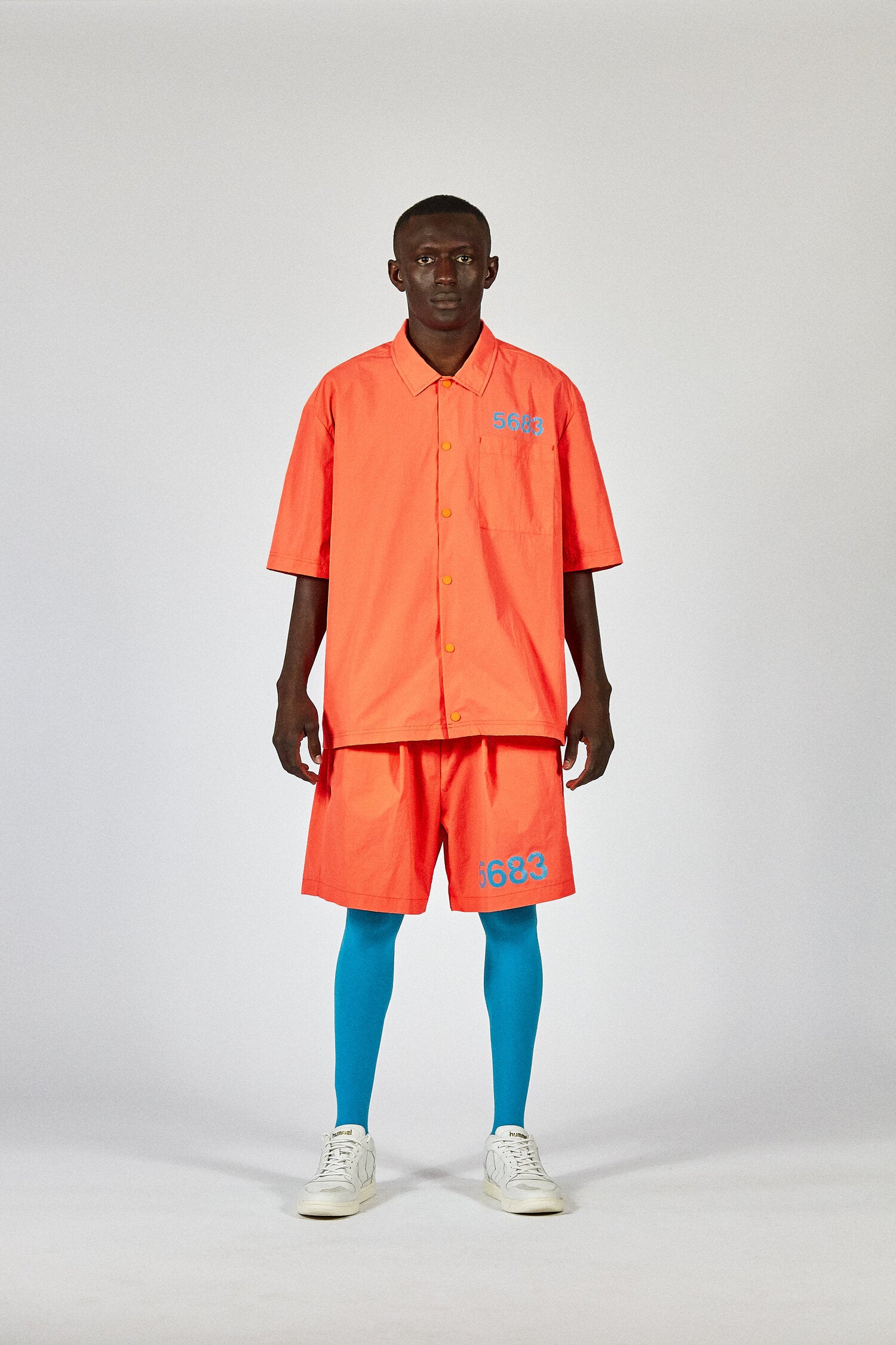 Willy Chavarria (ウィリーチャバリア) × hummel (ヒュンメル) HOME BOY SHIRT SHOCKING ORANGE 20SSコラボレーションアイテム。モデル画像。