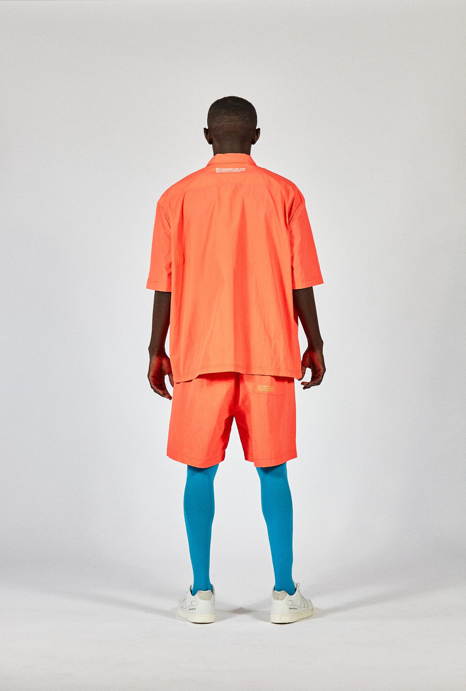 Willy Chavarria (ウィリーチャバリア) × hummel (ヒュンメル) HOME BOY SHIRT SHOCKING ORANGE 20SSコラボレーションアイテム。モデル画像。